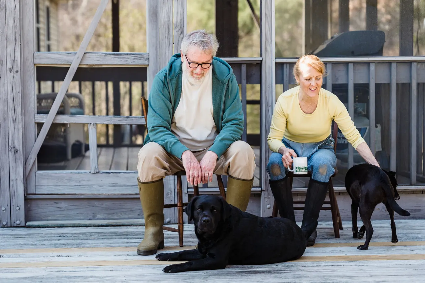 Couple on a porch with their two dogs